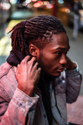 African American man in black hoodie on city street at night
