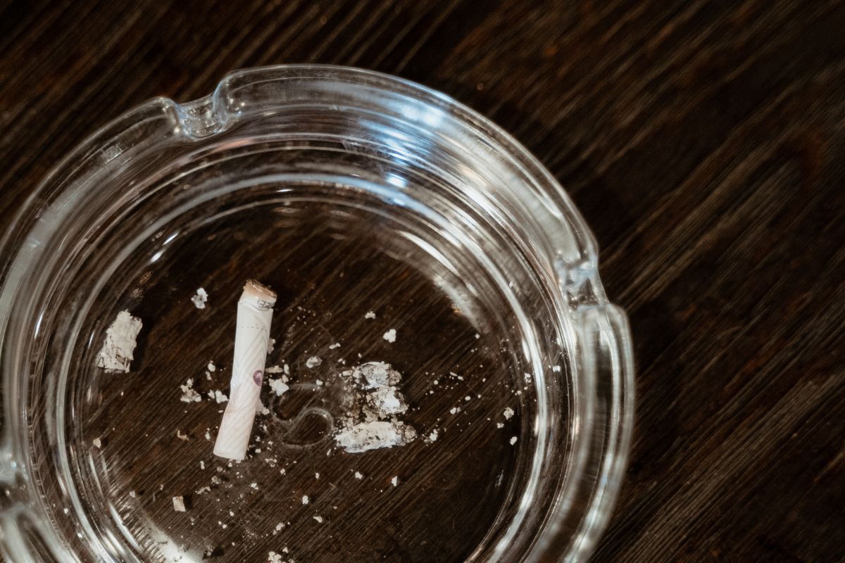 Clear glass ashtray on dark wood, premium smoke accessory